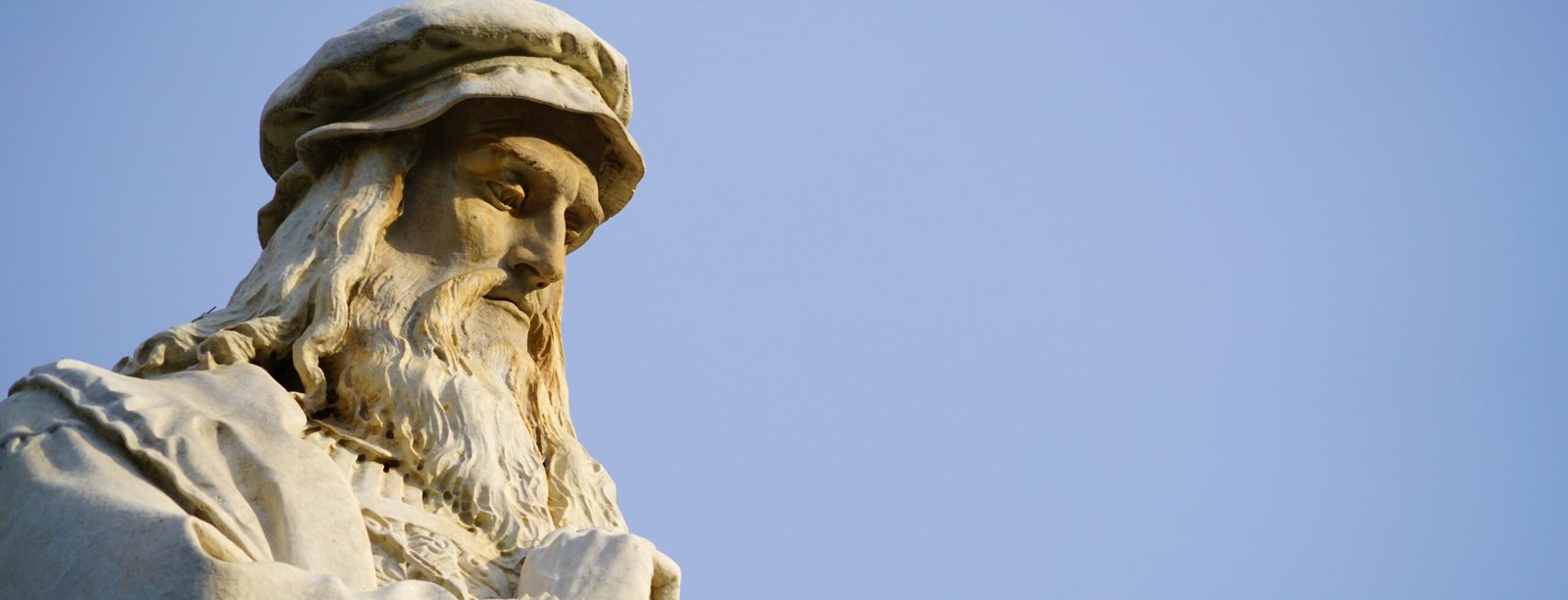 Head of the Leonardo da Vinci statue in Milan, the blue sky in the background