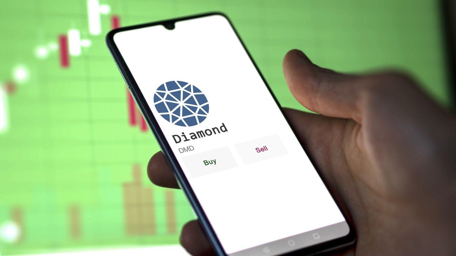 March 11 2023 London UK. An investor's analyzing the Diamond coin on screen. A phone shows the crypto's prices to invest in DMD